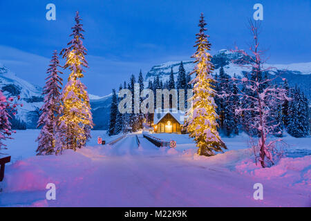 Emerald Lake Lodge Cabin British Columbia Kanada während der Blauen Stunde Mitte Winter und Weihnachten Lichter auf den Bäumen. Stockfoto