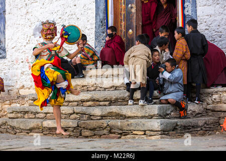 Prakhar Lhakhang, Bumthang, Bhutan. Young Boys auf Kloster Schritte beobachten Buddhistische Mönche einen Tanz in der Duechoed religiöses Fest, Verschleiß Stockfoto