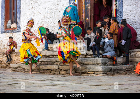 Prakhar Lhakhang, Bumthang, Bhutan. Young Boys auf Kloster Schritte beobachten Buddhistische Mönche einen Tanz in der Duechoed religiöses Fest, Verschleiß Stockfoto