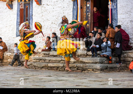 Prakhar Lhakhang, Bumthang, Bhutan. Young Boys auf Kloster Schritte beobachten Buddhistische Mönche einen Tanz in der Duechoed religiöses Fest, Verschleiß Stockfoto