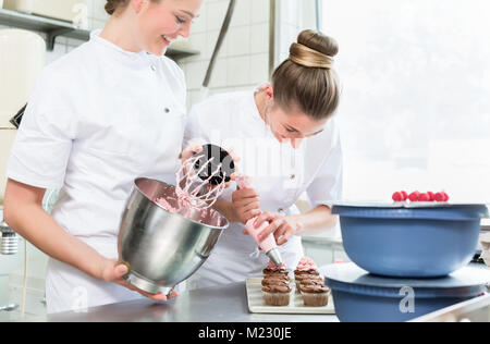 Pasty baker Frauen setzen Sie die Creme auf die Kuchen Stockfoto