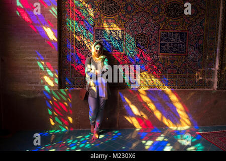 Ein Tourist steht in das Licht, das durch die Stain Glass Windows der Nasir al Molk Moschee in Shiraz Stockfoto