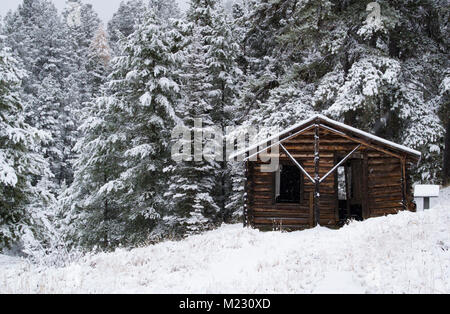 Eine verschneite Blockhütte, Granat Ghost Town, auf Bear Gulch, nordwestlich von Drummond, Montana in Granit County. Stockfoto