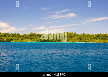 Togian Inseln Reiseziel, Togean Inseln malerischen Strand und Küste mit üppigen, grünen Dschungel im türkisblauen Meer, Sulawesi, Indonesien. Stockfoto