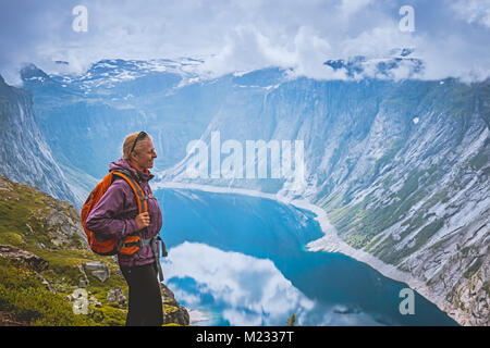 Junge Frau mit Rucksack Fjord Küste Stockfoto