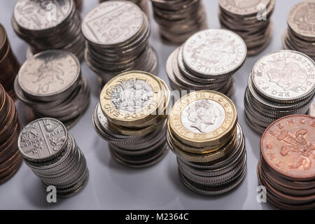 Stapel von verschiedenen britischen Münzen auf einem weißen Hintergrund. Stockfoto
