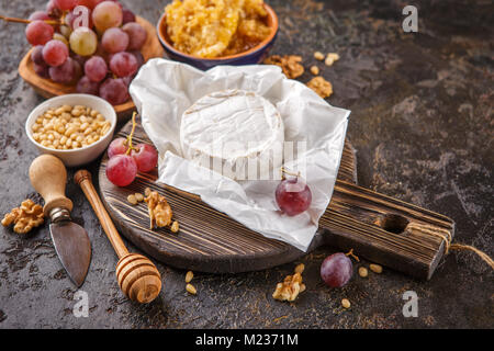 Camembert Käse mit Trauben, Honig in den Waben mit Zedern- und Walnüsse und Mandeln Stockfoto