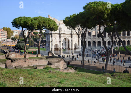 Der Torbogen von Konstantin mit dem Colosseum hinter mit Massen von Touristen, aus dem unteren Teil des Palatin in Rom Stockfoto