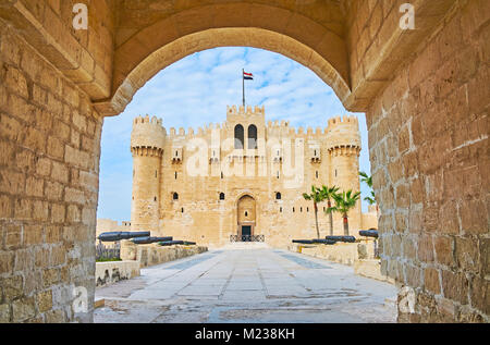 Der Blick auf die qaitbay Fort durch seinen Eingang Stone Gate, die Gasse mit Kanonen auf Vordergrund, Alexandria, Ägypten gesehen. Stockfoto