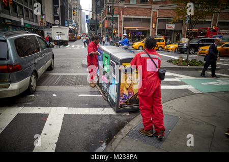 New York City Manhattan, Times Square Straßenreinigung Verschieben einer Recycling Mülleimer Stockfoto