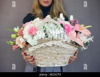 Die schöne rustikale Blumenstrauß auf Weidenkorb in Frau Hände Stockfoto