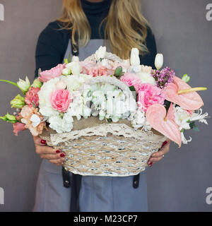 Die schöne rustikale Blumenstrauß auf Weidenkorb in Frau Hände Stockfoto