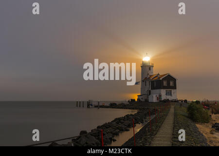 Leuchtturm bezeichnet das Pferd der Marken leuchtet ein bunter Himmel über das IJsselmeer, Niederlande. Lange Belichtung Landschaftsfotos leuchtet bei Mondschein. Stockfoto