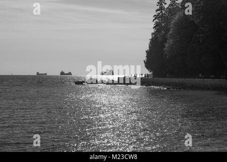 Vancouver, British Columbia, Kanada. English Bay und dem Stanley Park Seawall an einem Sommerabend in Schwarzweiß. Stockfoto