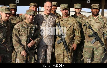 Marine Corps Gen. Joe Dunford, Vorsitzender des Generalstabs, nimmt ein Gruppenfoto mit Soldaten an der USO Holiday Tour an Taji militärische Komplex, Dez. 25, 2017. Dunford und Troxell, zusammen mit USO Animateure, besuchte Service für Mitglieder, die während der Feiertage bereitgestellt werden. Animateure sind in diesem Jahr die Küchenchef Robert Irvine, Wrestler Gail Kim, Comedian Iliza Shlesinger, Schauspieler Adam Devine, Land Musiker Jerrod Niemann, und WWE Superstars" Die Miz" und Alicia Fox. (U.S. Armee Foto von 1 Lt Darren T. Hering jr.) Stockfoto