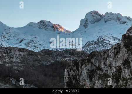 Sonnenaufgang in den Bergen von Ubina, zwischen Asturien und Leon, an einem Wintertag mit viel Schnee, in den frühen Morgenstunden zu fotografieren, die eindeutigen Farben Stockfoto