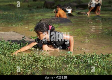 Wenig kambodschanische Mädchen in einem Teich, Bayon Tempel, Angkor, Kambodscha Stockfoto