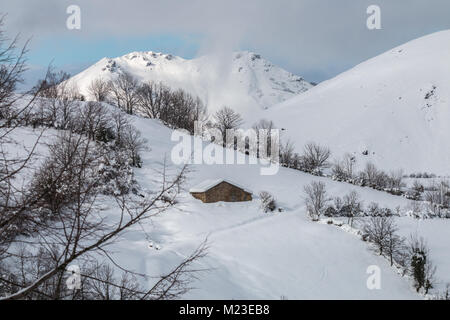 Sonnenaufgang in den Bergen von Ubina, zwischen Asturien und Leon, an einem Wintertag mit viel Schnee, in den frühen Morgenstunden zu fotografieren, die eindeutigen Farben Stockfoto