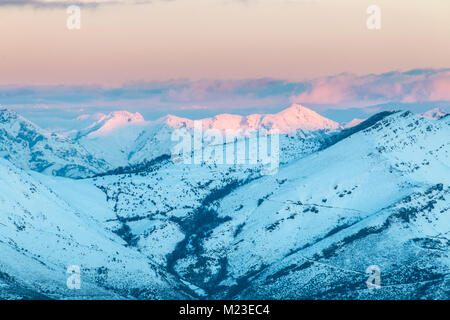 Sonnenaufgang in den Bergen von Ubina, zwischen Asturien und Leon, an einem Wintertag mit viel Schnee, in den frühen Morgenstunden zu fotografieren, die eindeutigen Farben Stockfoto