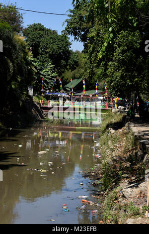 Müll nach unten fließt ein kleiner Fluss in Indonesien, neben einem Slum Gegend, die bemalten Dorf Stockfoto