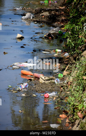 Müll nach unten fließt ein kleiner Fluss in Indonesien, neben einem Slum Gegend, die bemalten Dorf Stockfoto