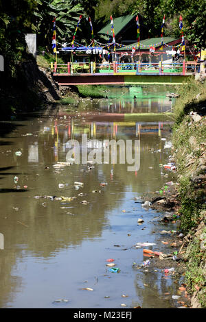 Müll nach unten fließt ein kleiner Fluss in Indonesien, neben einem Slum Gegend, die bemalten Dorf Stockfoto