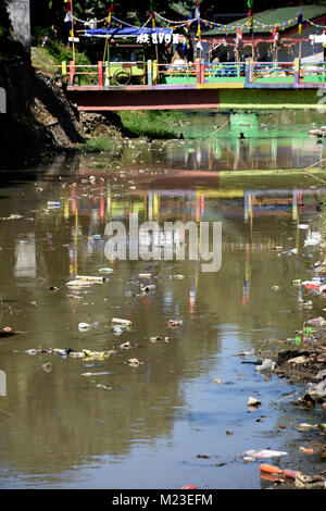 Müll nach unten fließt ein kleiner Fluss in Indonesien, neben einem Slum Gegend, die bemalten Dorf Stockfoto