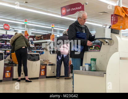 Drei Kunden zahlen für ihre Einkaufsmöglichkeiten im Self Checkout Bereich von Sainsbury's Supermarkt in Bourne, Lincolnshire, England, UK. Stockfoto