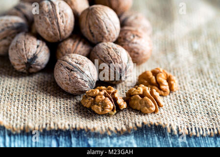 Walnüsse und Kernel auf Leinwand auf Holz- Hintergrund Stockfoto
