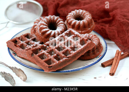 Hausgemachte Schokolade Waffeln mit Kakao aus Vollkornmehl, mit Puderzucker auf einem weißen Tisch dekoriert, selektiver Fokus Stockfoto