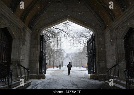 Ein leichter Schnee fällt auf Studenten zu Fuß durch die Cobb Tor an der Universität von Chicago. Stockfoto