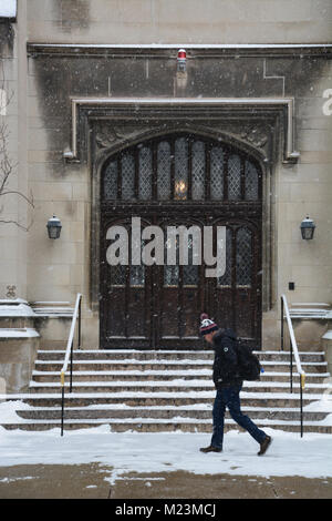 Ein Student Spaziergänge im Schnee letzten gotischen Türen zu Harper Memorial Library an der Universität von Chicago Campus. Stockfoto