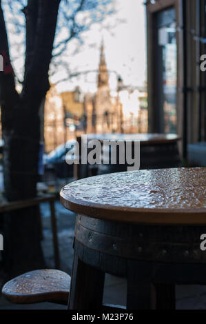 Ein Tisch und ein Stuhl, Regen fällt in eine Terrasse an der Straße von einer Bar in Edinburgh, Schottland. Stockfoto