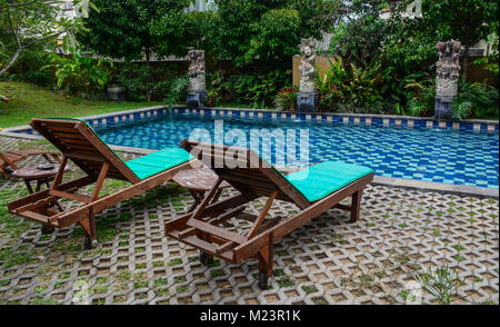Bali, Indonesien - Apr 20, 2016. Pool mit Stühlen aus Holz am Luxus Resort in Bali, Indonesien. Stockfoto