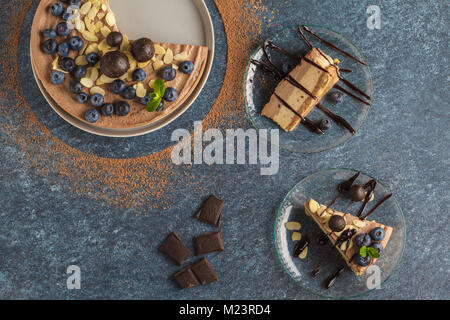 Raw vegan Schokolade - Karamell Käsekuchen mit Heidelbeeren, rohe Süßigkeit Kugeln und Mandeln. Gesunde vegane Ernährung Konzept. Stockfoto