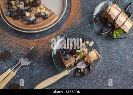 Raw vegan Schokolade - Karamell Käsekuchen mit Heidelbeeren, rohe Süßigkeit Kugeln und Mandeln. Gesunde vegane Ernährung Konzept. Stockfoto