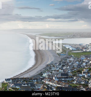 Die klassische Ansicht der Chesil Beach, mit der Flotte Lagune, Portland Harbour und Chiswell/Fortuneswell Stadt hinter sich, als der Gipfel von Portland gesehen Stockfoto