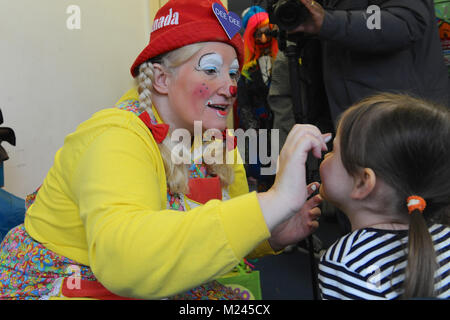 Dee Dee der Clown Anwendung Make-up mit einem kleinen Kind kurz vor dem 72. jährlichen Grimaldi Clown Gottesdienst in Alle Angaben zum Heiligen Kirche, Hackney, London, Vereinigtes Königreich. Der Service, der zu einer jährlichen Tradition seit 1946, wird in Erinnerung an Joseph "Joey" Clown Grimaldi (1778-1837), der am meisten gefeierten englischen Clown, geboren wurde und in London durchgeführt. Die einzigartige Gottesdienst ist an jedem ersten Sonntag im Februar statt und einen Kranz zu Ehren der Grimaldi. Quelle: Michael Preston/Alamy leben Nachrichten Stockfoto