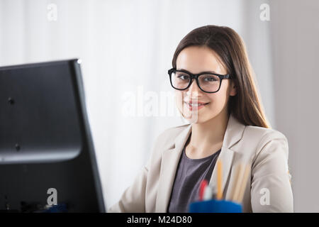 Porträt eines lächelnden Jungen Geschäftsfrau mit schwarzen Brillen in Office Stockfoto