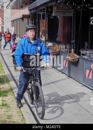 Polizisten auf einem Fahrrad führt Routine Patrol auf einer Stadt Bürgersteig in der Innenstadt von Montgomery, Alabama in den Vereinigten Staaten. Stockfoto