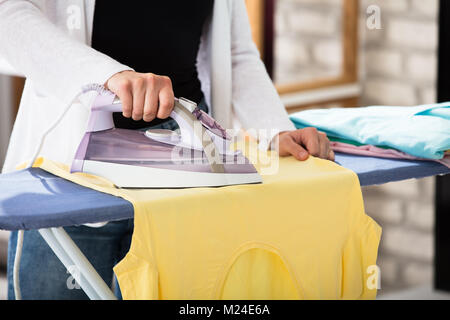 Nahaufnahme einer Frau Brett T-Shirt auf dem Bügelbrett zu Hause Stockfoto