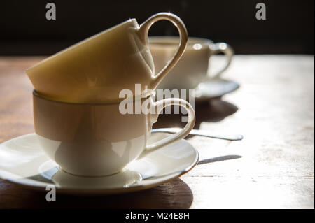 Leere schmutzige Kaffeetassen auf einen hölzernen Tisch im Zimmer. Stockfoto