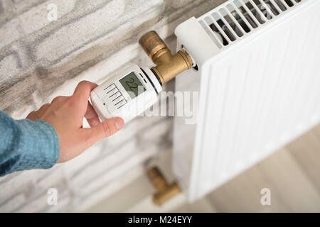 Einer Person Hand Einstellen der Temperatur am Thermostat des Kühlers Stockfoto