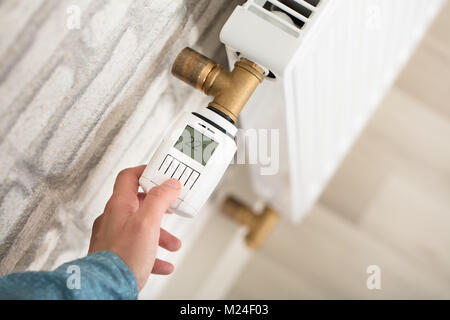 Einer Person Hand Einstellen der Temperatur am Thermostat des Kühlers Stockfoto