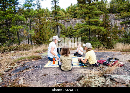 Eine Großmutter und ihr Enkel haben ein Picknick auf einem Felsen im nördlichen Ontario Stockfoto