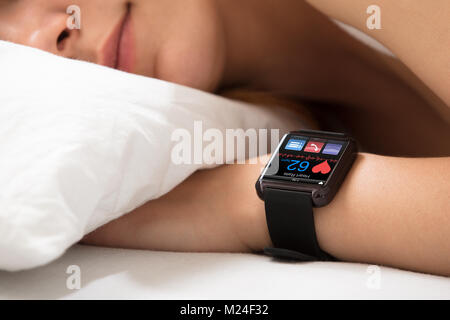 Smart Watch zeigt Heartbeat Rate auf Sleeping Woman's Hand Stockfoto