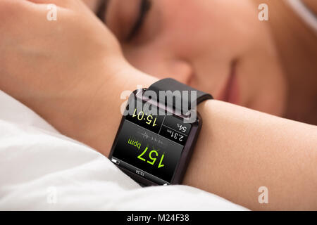 Smart Watch zeigt Heartbeat Rate auf Sleeping Woman's Hand Stockfoto