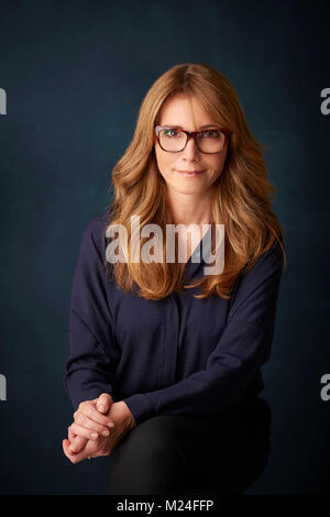 Portrait von wunderschöne reife Frau gegen am grauen Hintergrund posiert Stockfoto