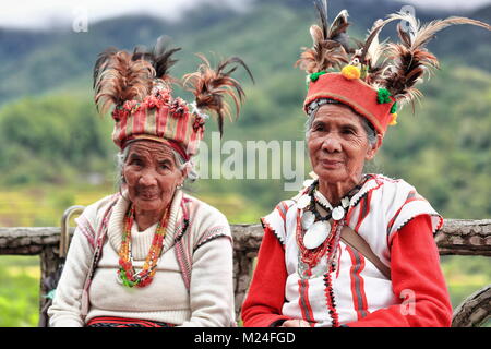 Banaue, Philippines-October 8, 2016: Einige ältere Ifugaos - Männer und Frauen - noch Kleid in ihrer traditionellen Kleidung und Kopfbedeckung während der Sitzung durch die r Stockfoto