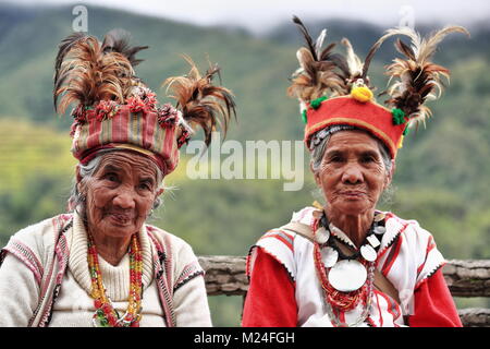 Banaue, Philippines-October 8, 2016: Einige ältere Ifugaos - Männer und Frauen - noch Kleid in ihrer traditionellen Kleidung und Kopfbedeckung während der Sitzung durch die r Stockfoto